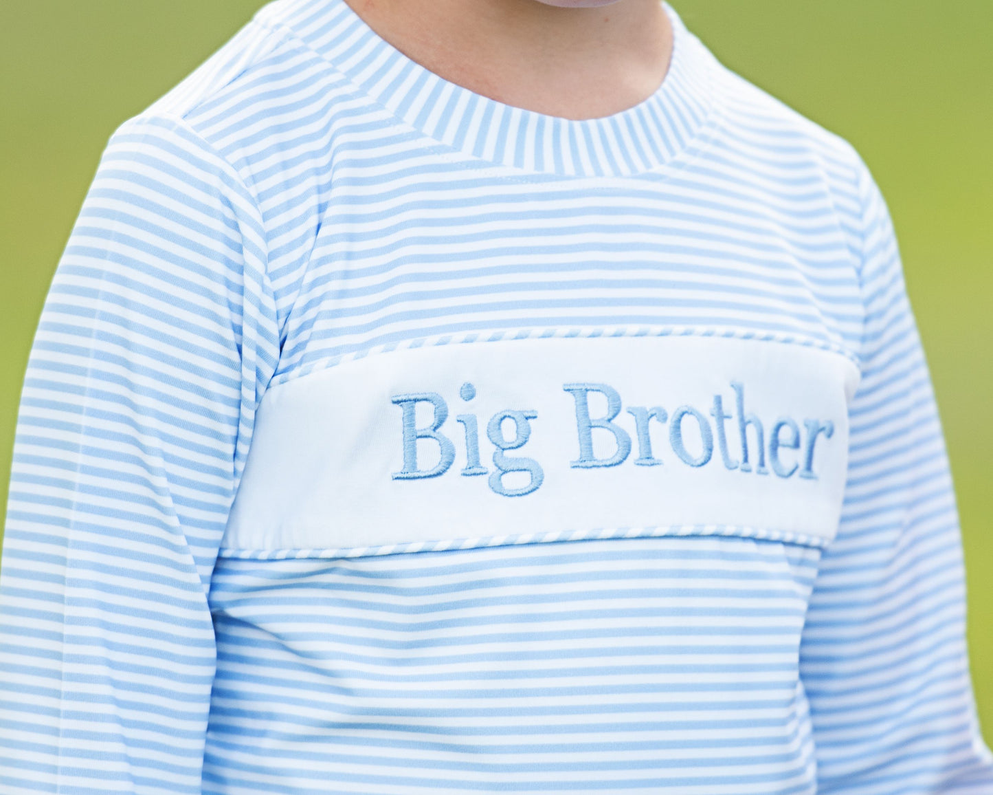 Blue and white striped shirt with 'Big Brother' text on a green background