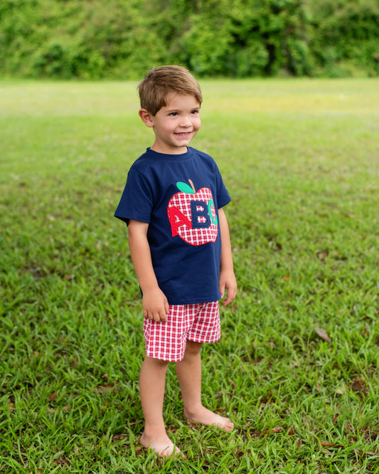 Boy in grassy field wearing an ABC outfit.