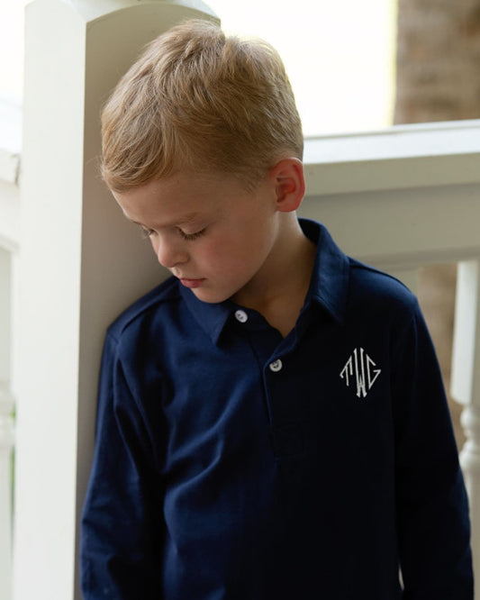 Boy wearing a navy shirt with a monogram