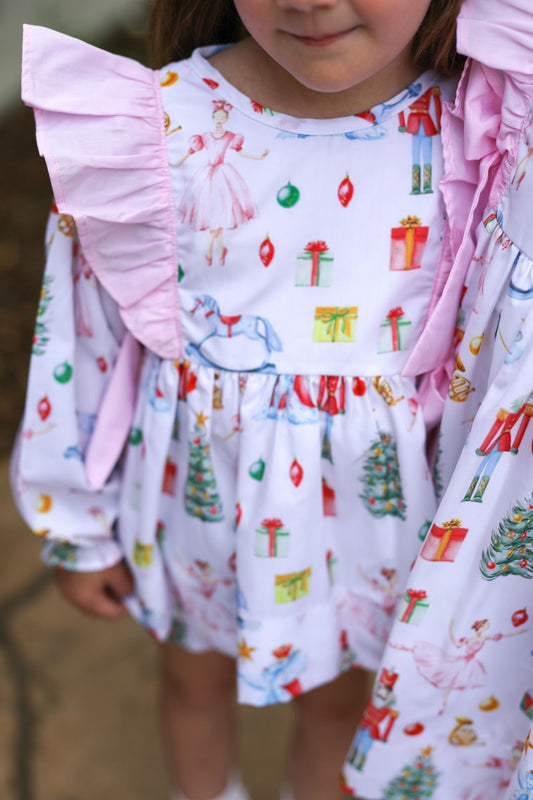 Child wearing a festive dress with Christmas-themed patterns
