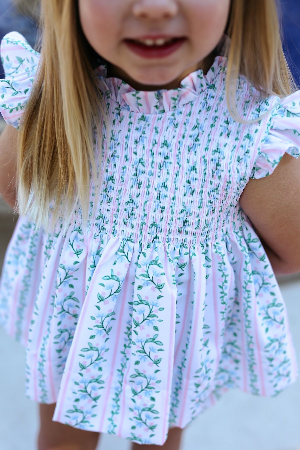 Child wearing a floral dress with a blurred background