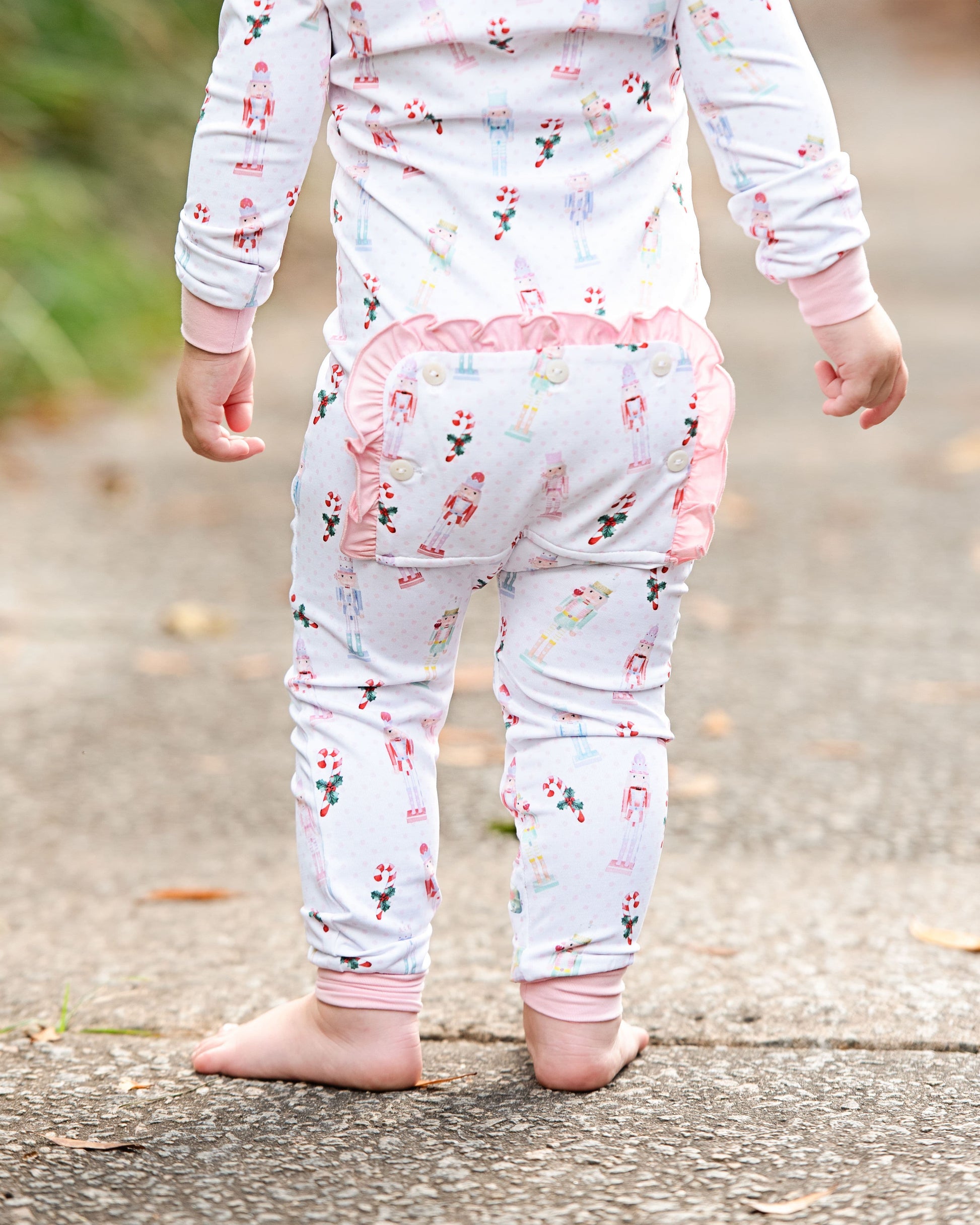 Child wearing a floral outfit with pink accents on a blurred outdoor background
