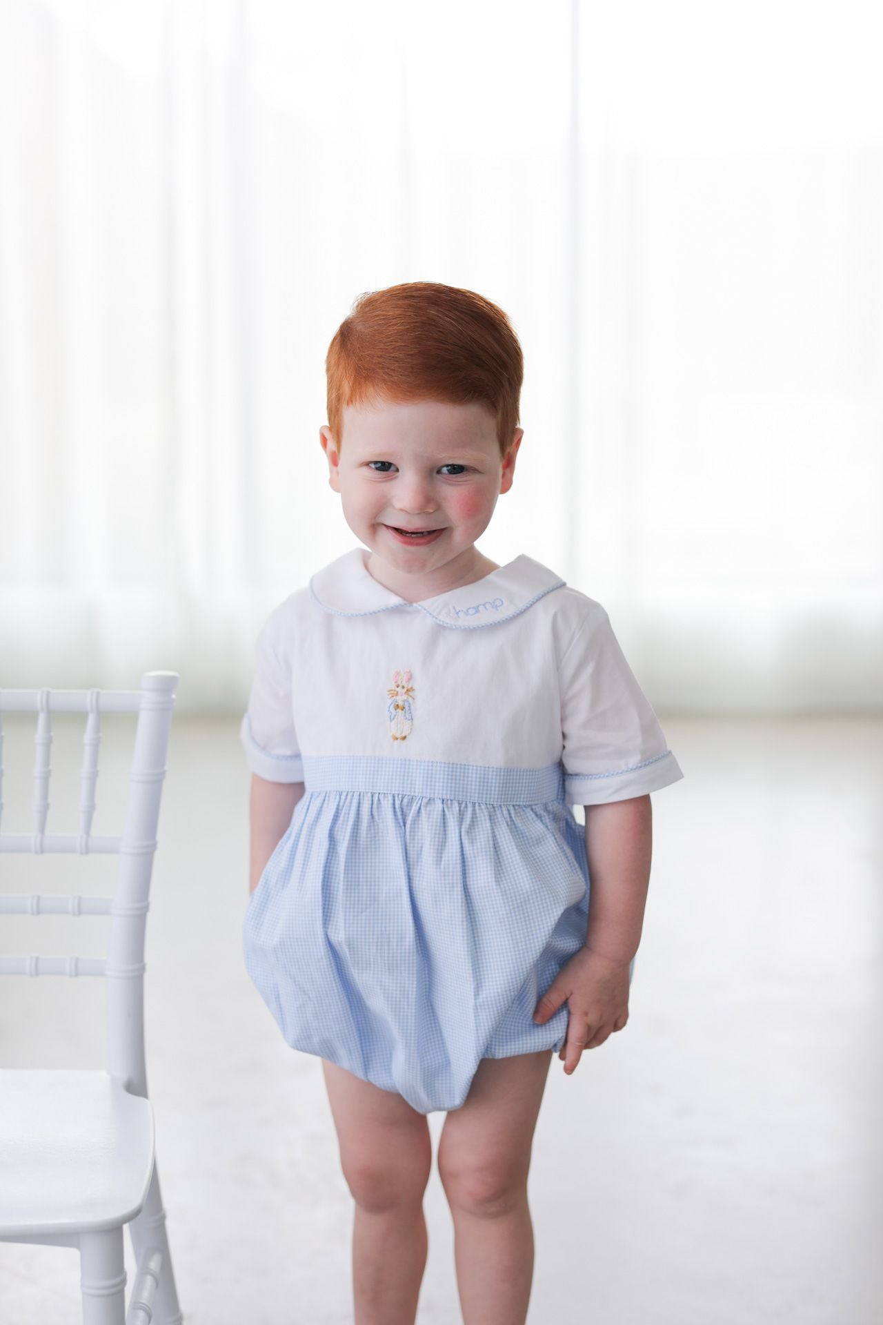 Child wearing a light blue bubble with a white top against a white background