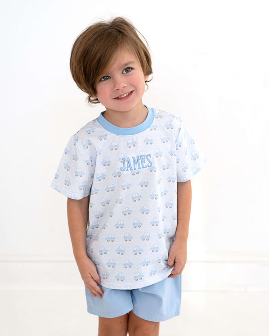 Child wearing a light blue pajama set with 'James' printed on the shirt against a white background