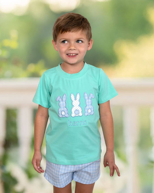 Child wearing a light blue t-shirt with bunny designs outdoors