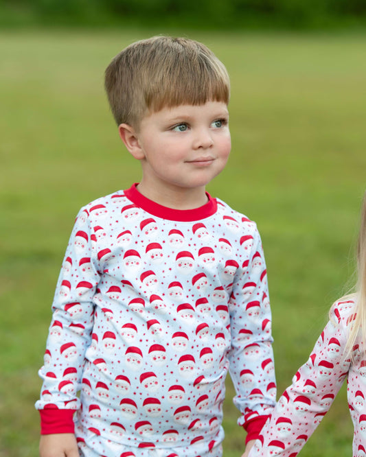 Child wearing a pajama with Santa hats pattern outdoors