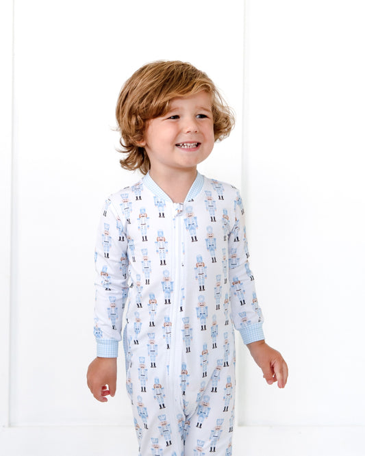 Child wearing a patterned onesie on a white background