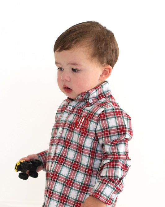 Child wearing a red and white plaid shirt holding a toy on a white background