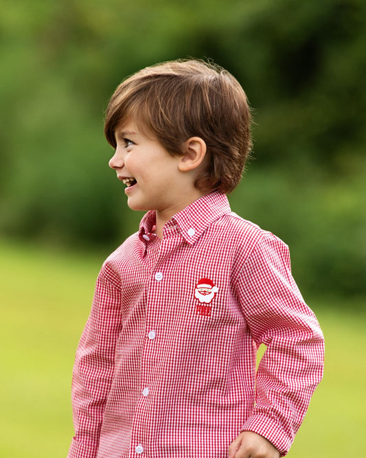 Child wearing a red checkered shirt with a logo outdoors3