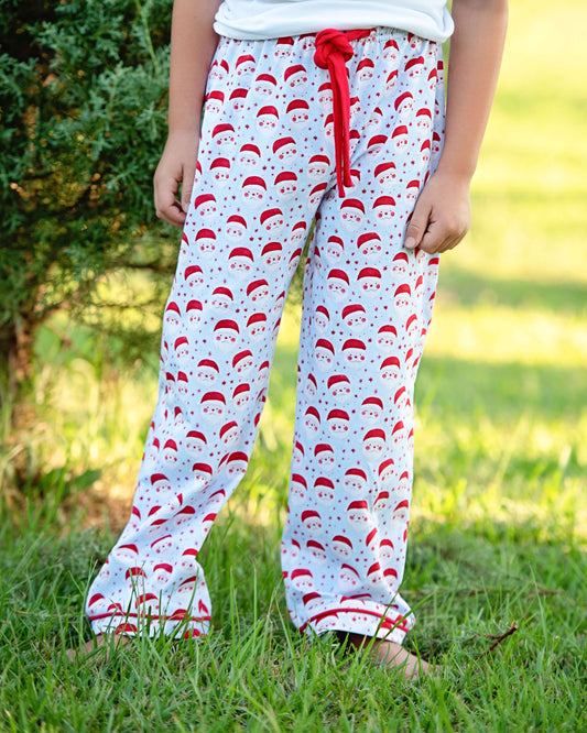 Child wearing pajama pants with Santa Claus pattern outdoors