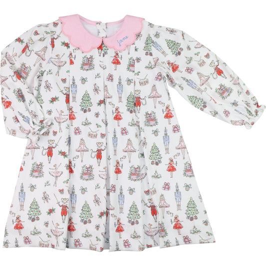 Children's dress with Christmas Nutcracker themed pattern on a white background