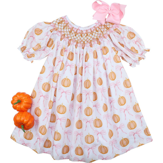 Children's dress with pumpkin and bow pattern on a white background