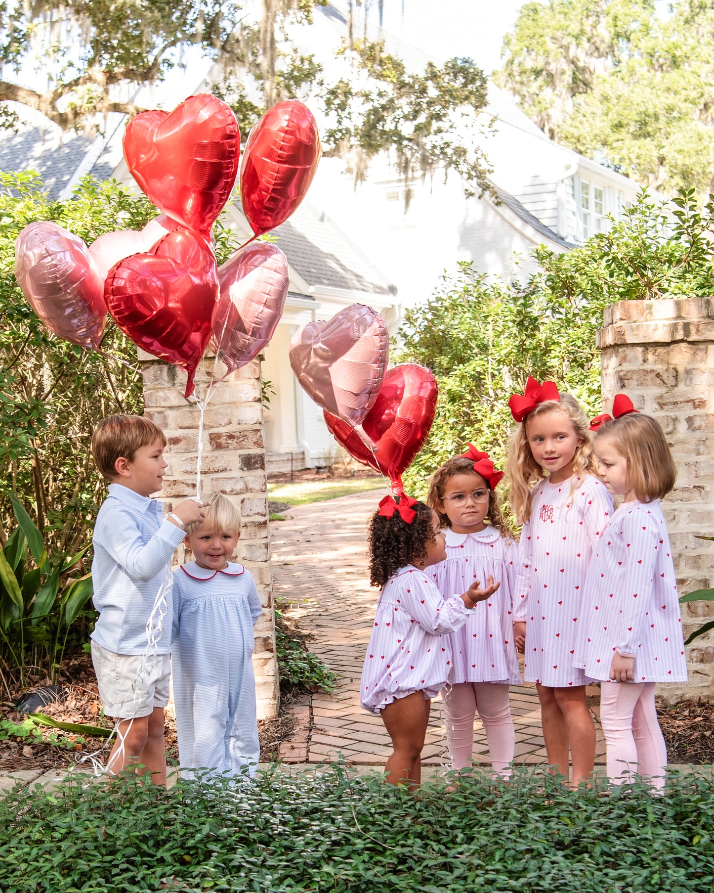 Children with heart-shaped balloons outside