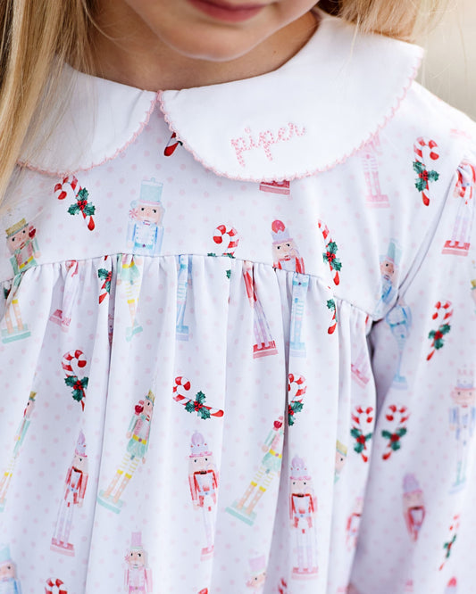 Close-up of a child's dress with nutcracker and candy cane pattern