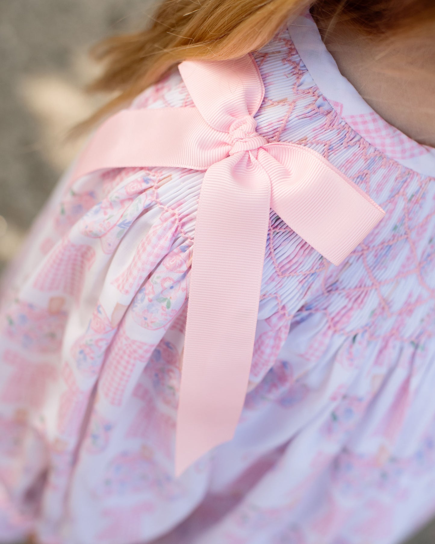 Close up of a dress with a pink bow detail blurred background