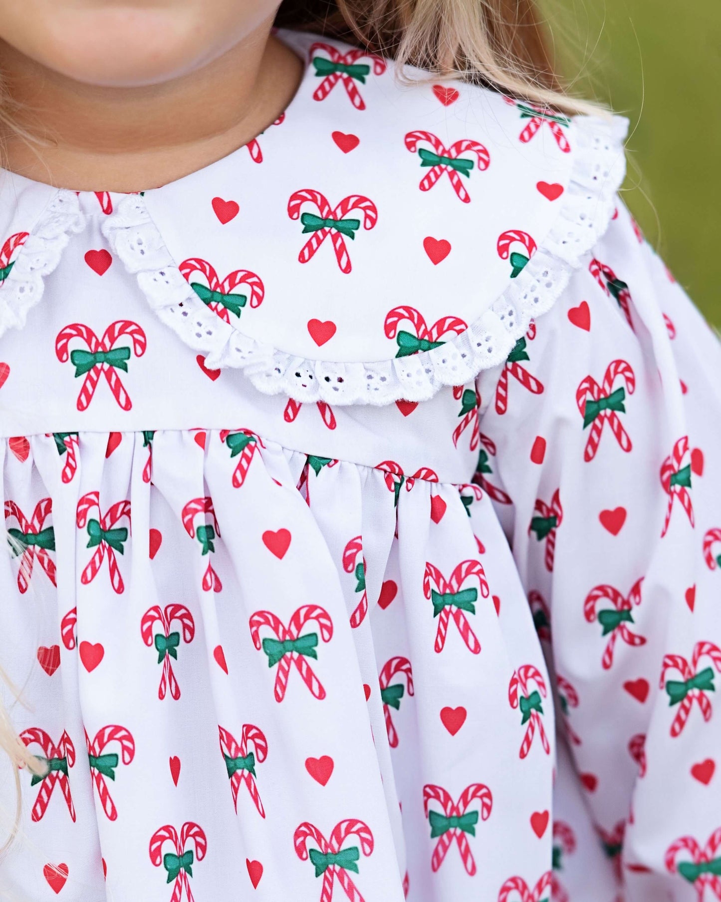 Close-up of a dress with candy cane and bow pattern on a white background