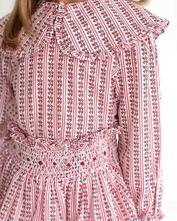 Closeup of red and green floral skirt set with smocking and tiny rosebuds on the skirt