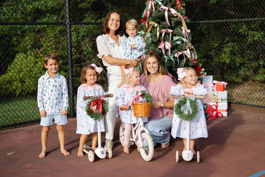 Family with children in front of a Christmas tree on a tennis court