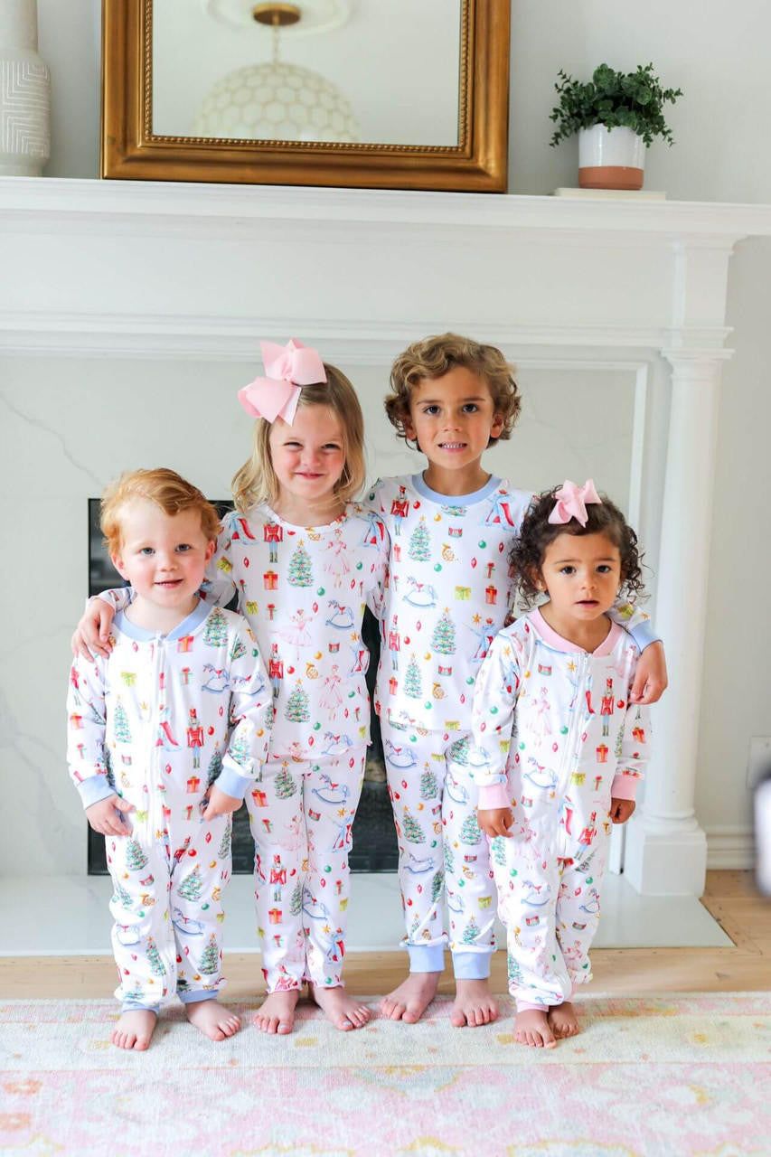 Four children in matching pajamas standing in a living room.