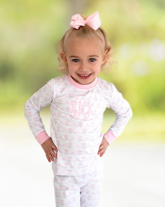 Girl wearing pajamas with hands on her hips smiling.