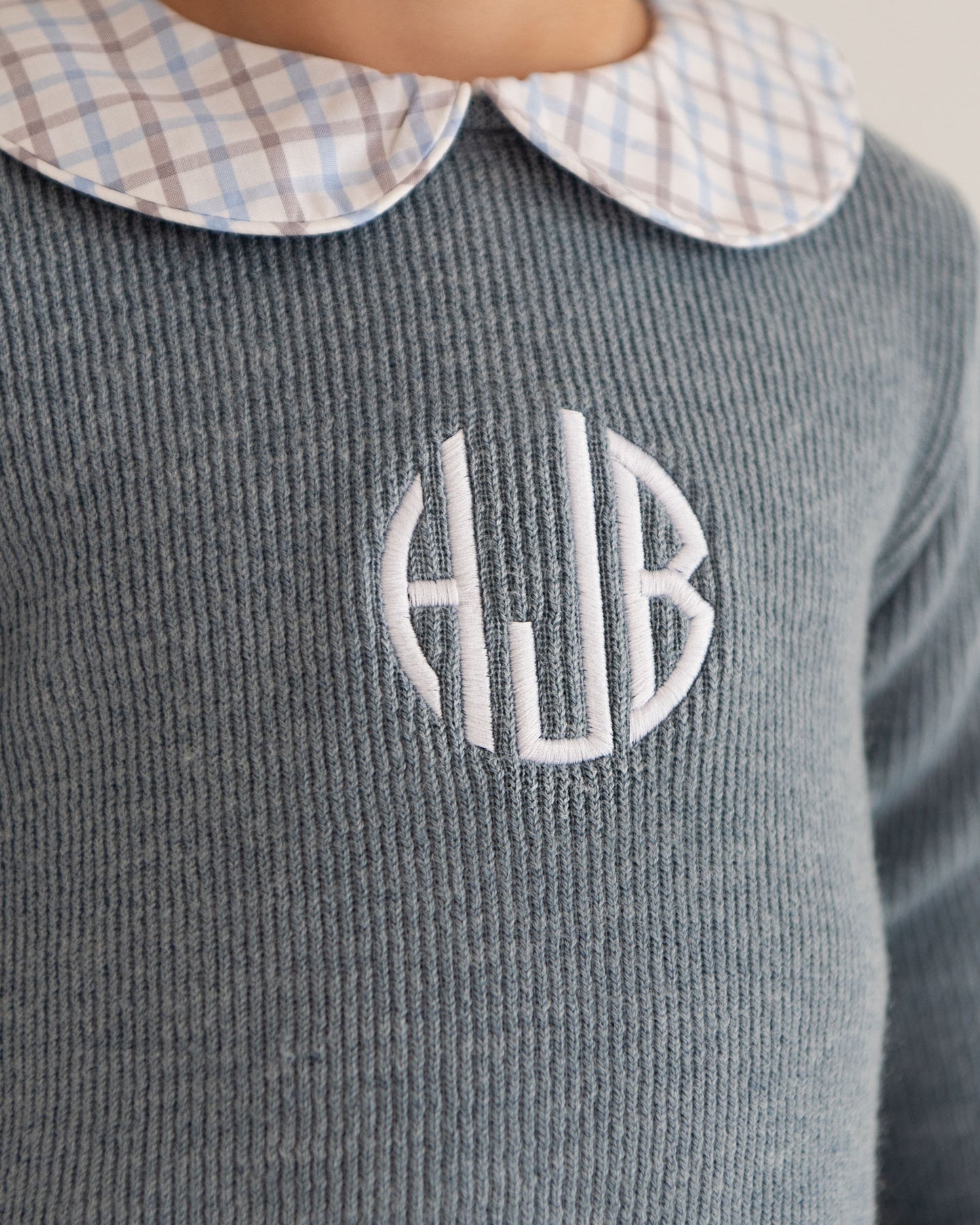 Gray textured sweater with 'HJB' monogram on a neutral background
