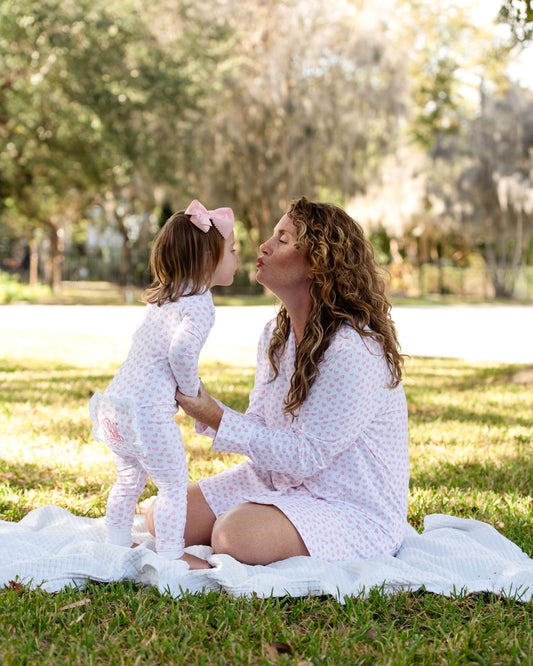 Lady and young girl wearing matching pink heart pajamas