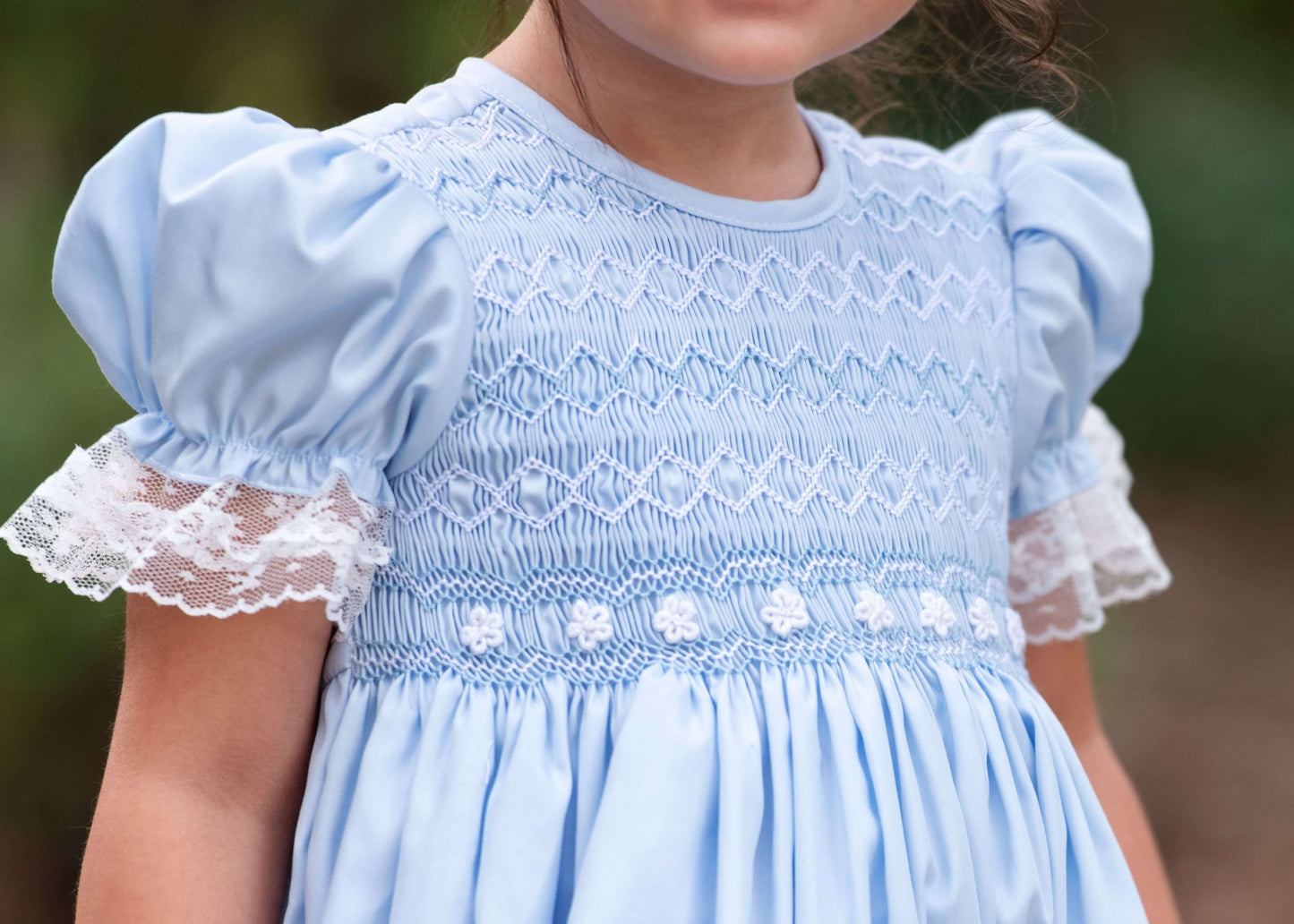 Light blue dress with lace details on a blurred background
