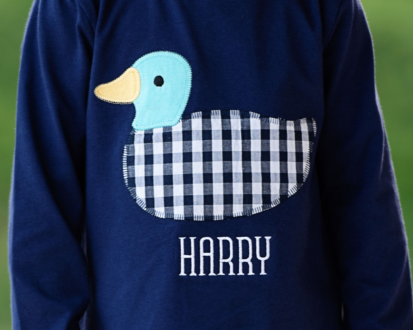 Navy blue shirt with a duck design and 'Harry' text on a green background