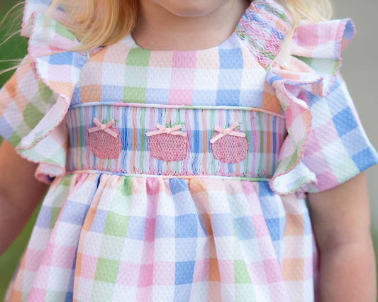 Pastel checkered dress with ruffled sleeves on a blurred background