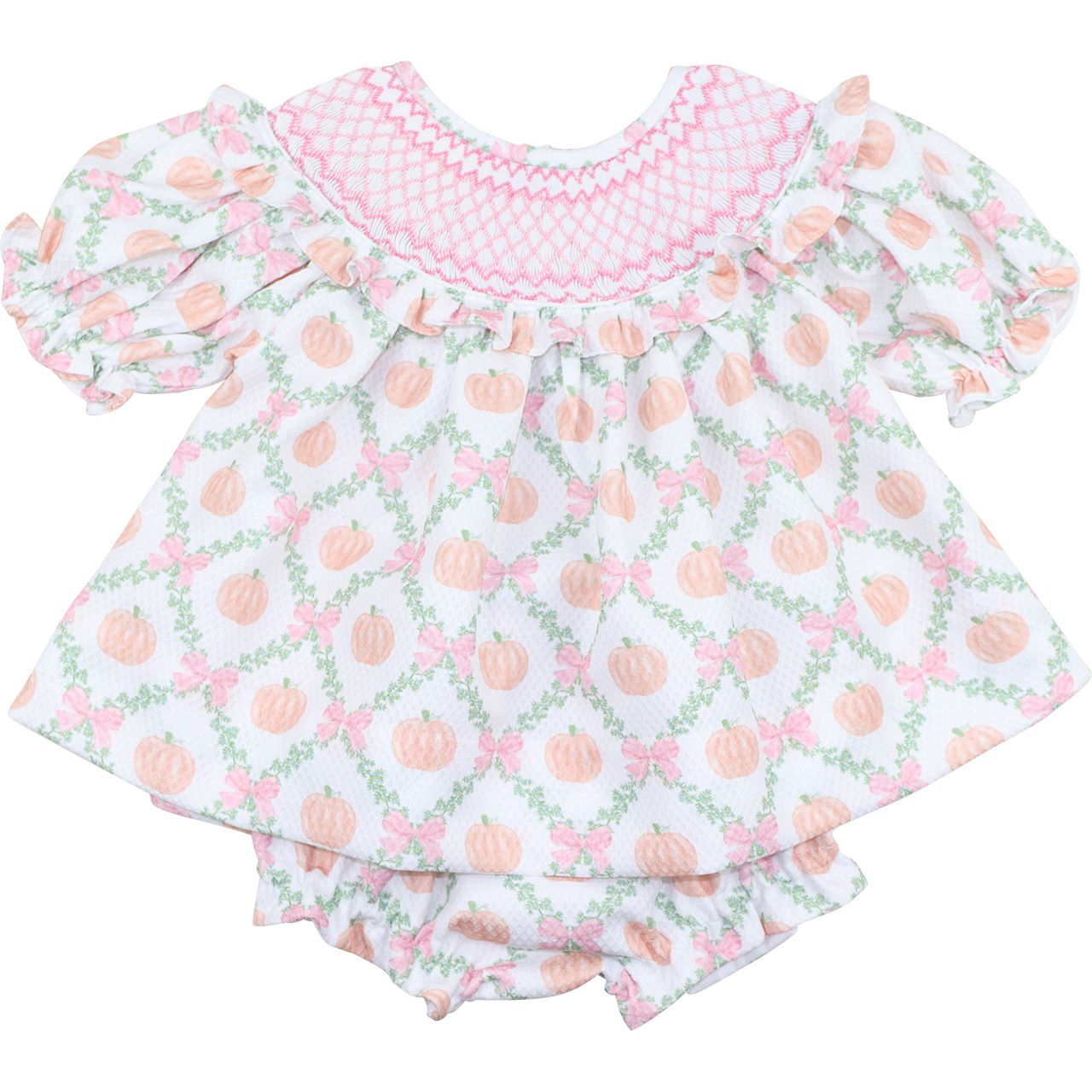 girl's diaper set with pink smocking and peach patterned dress on a white background