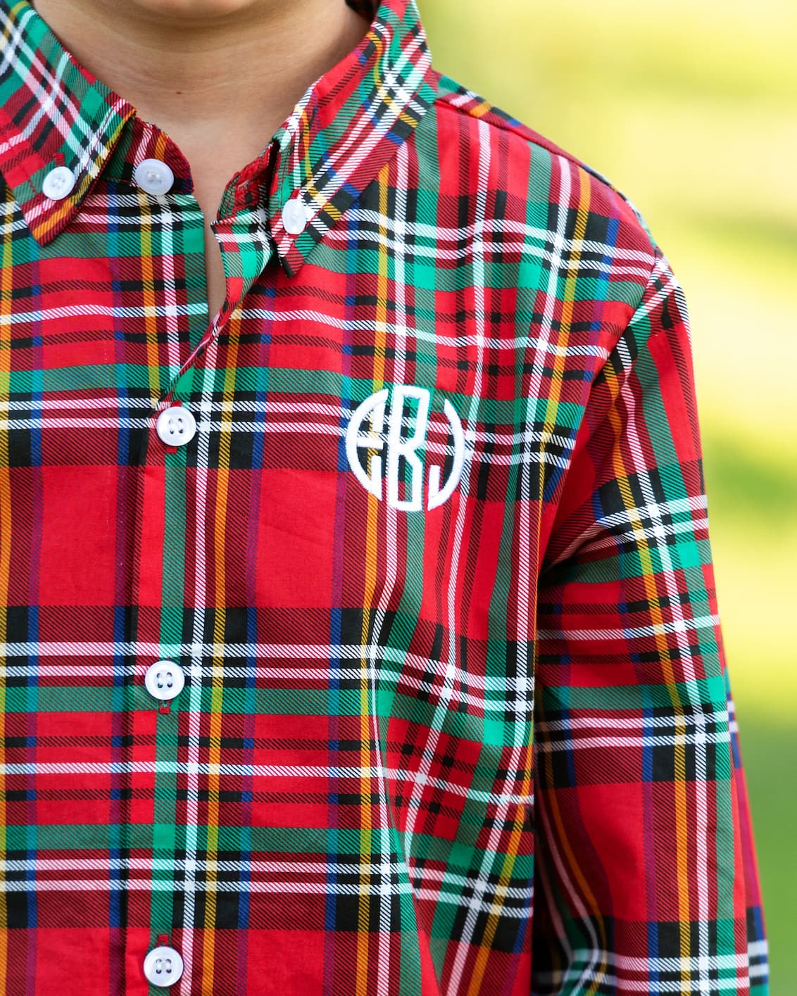 Red and green plaid shirt with a monogram on a blurred background
