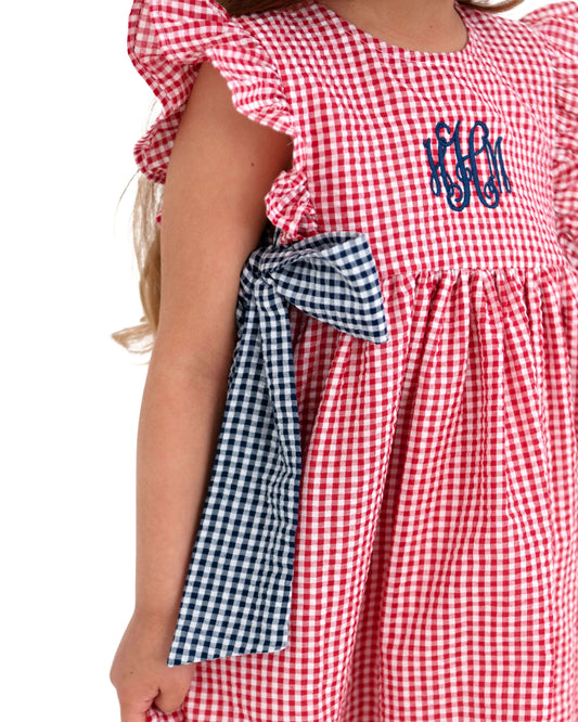 Red and white checkered dress with blue monogram on a white background