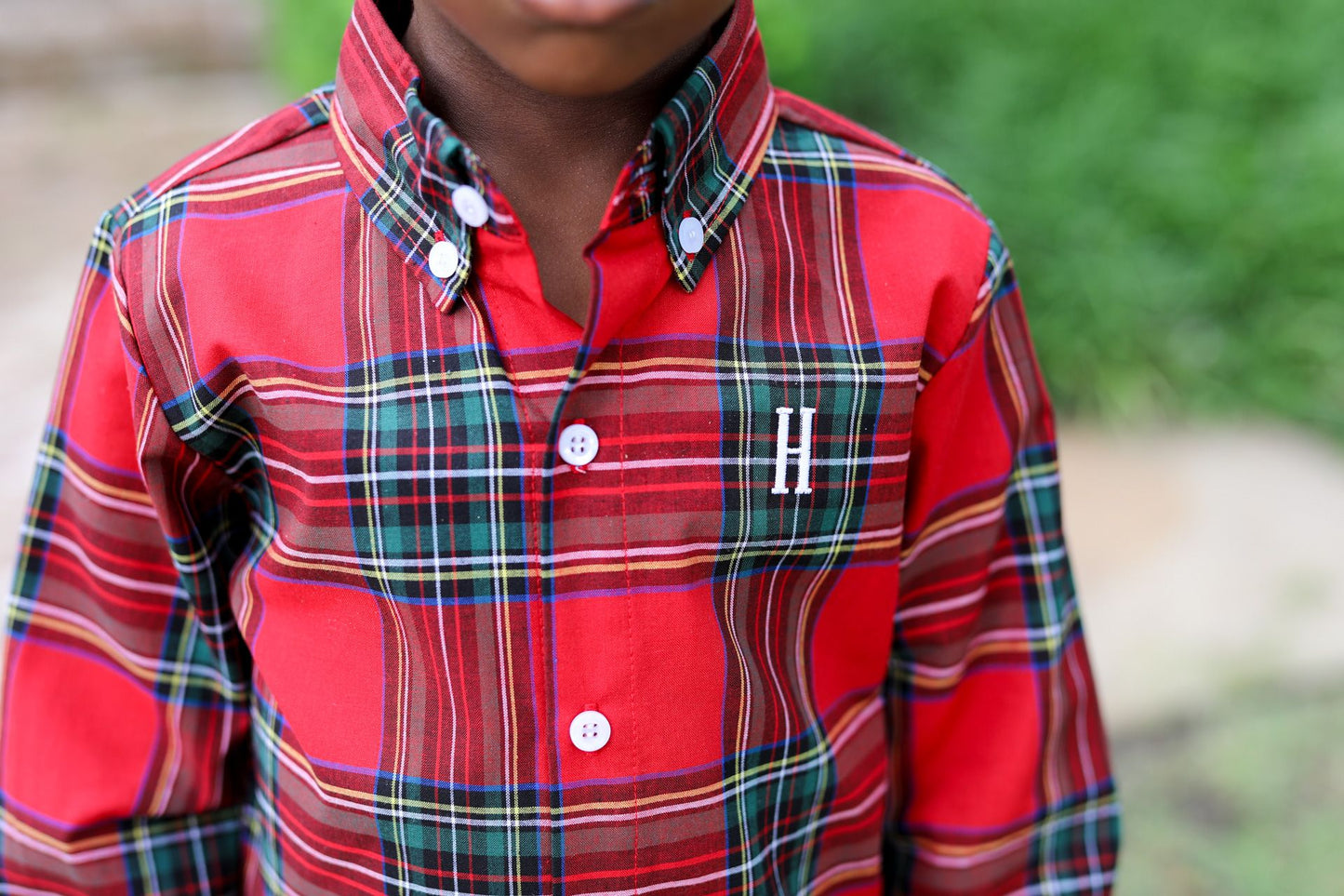 Red plaid shirt with a visible brand logo worn by a person outdoors.