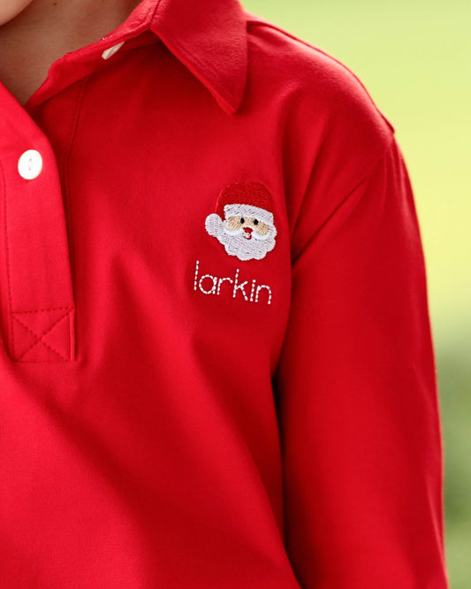 Red shirt with embroidered Santa Claus face and 'larkin' text on a blurred green background