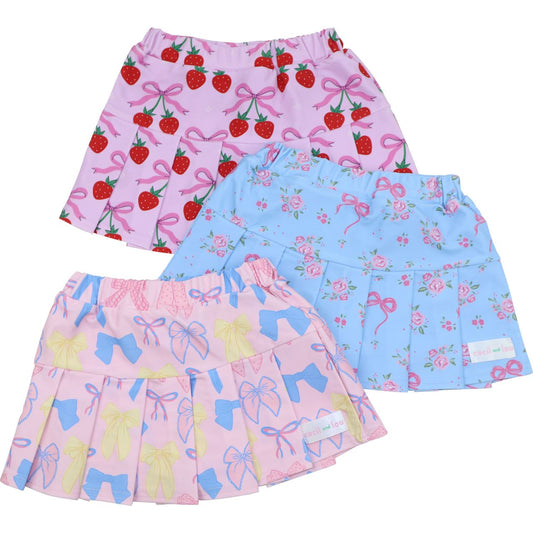 Set of three children's skirts with strawberry, floral, and butterfly patterns on a white background.