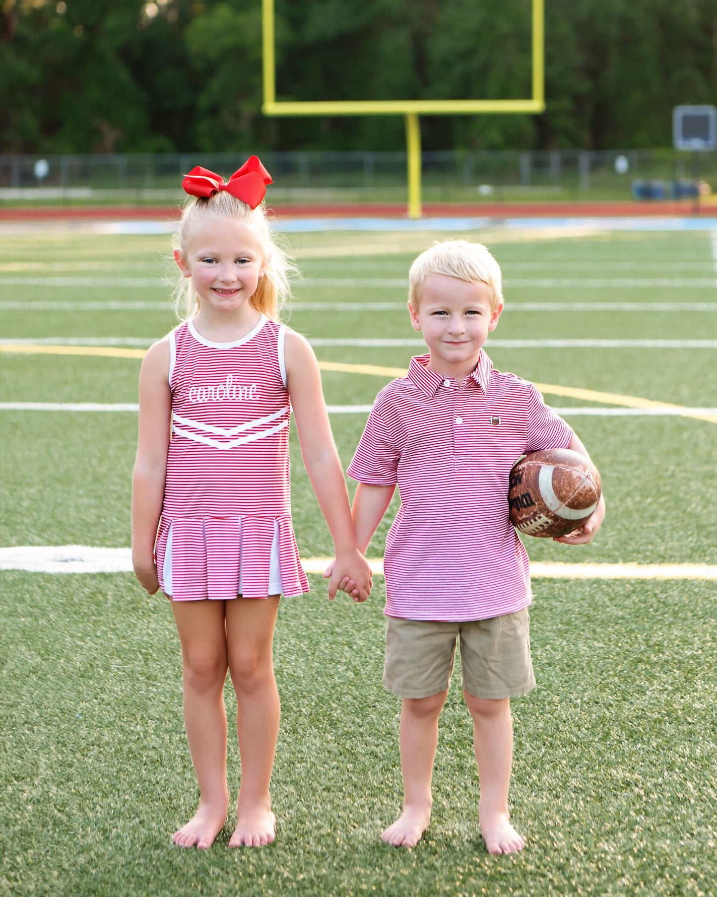 Two children holding hands with matching outfits