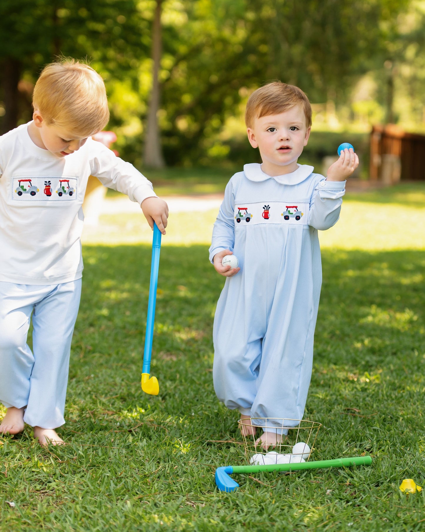 Two children playing with a toy golf set on grass