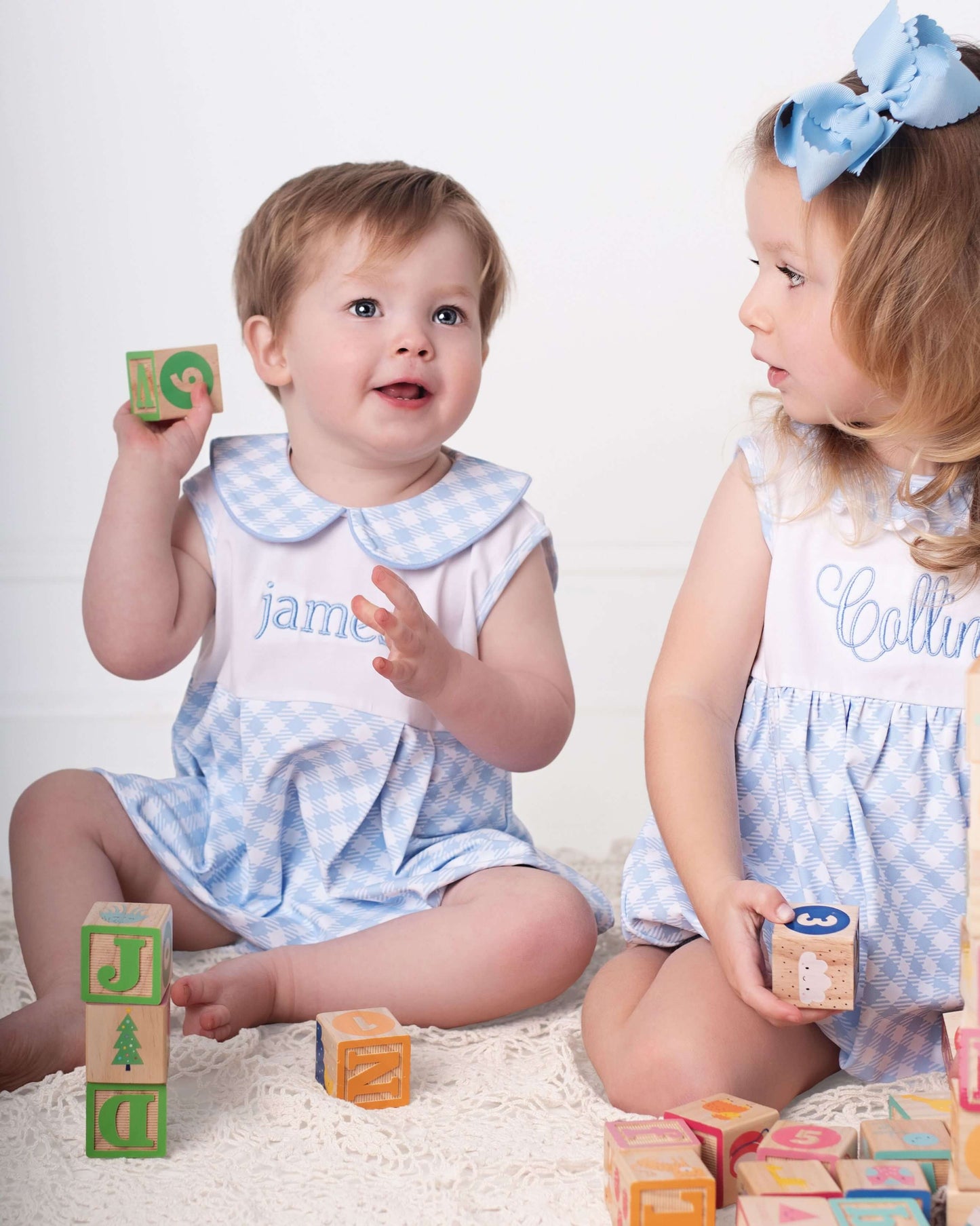 Two children playing with colorful blocks on a white background