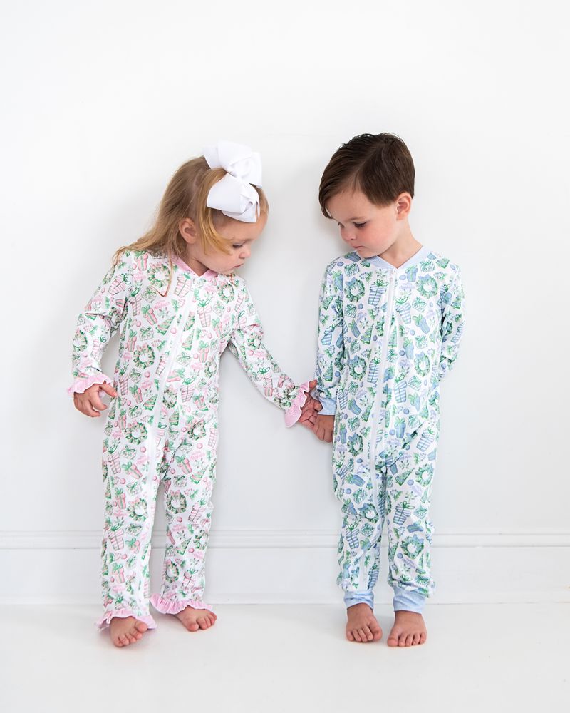 Two children wearing floral pajamas standing against a white background