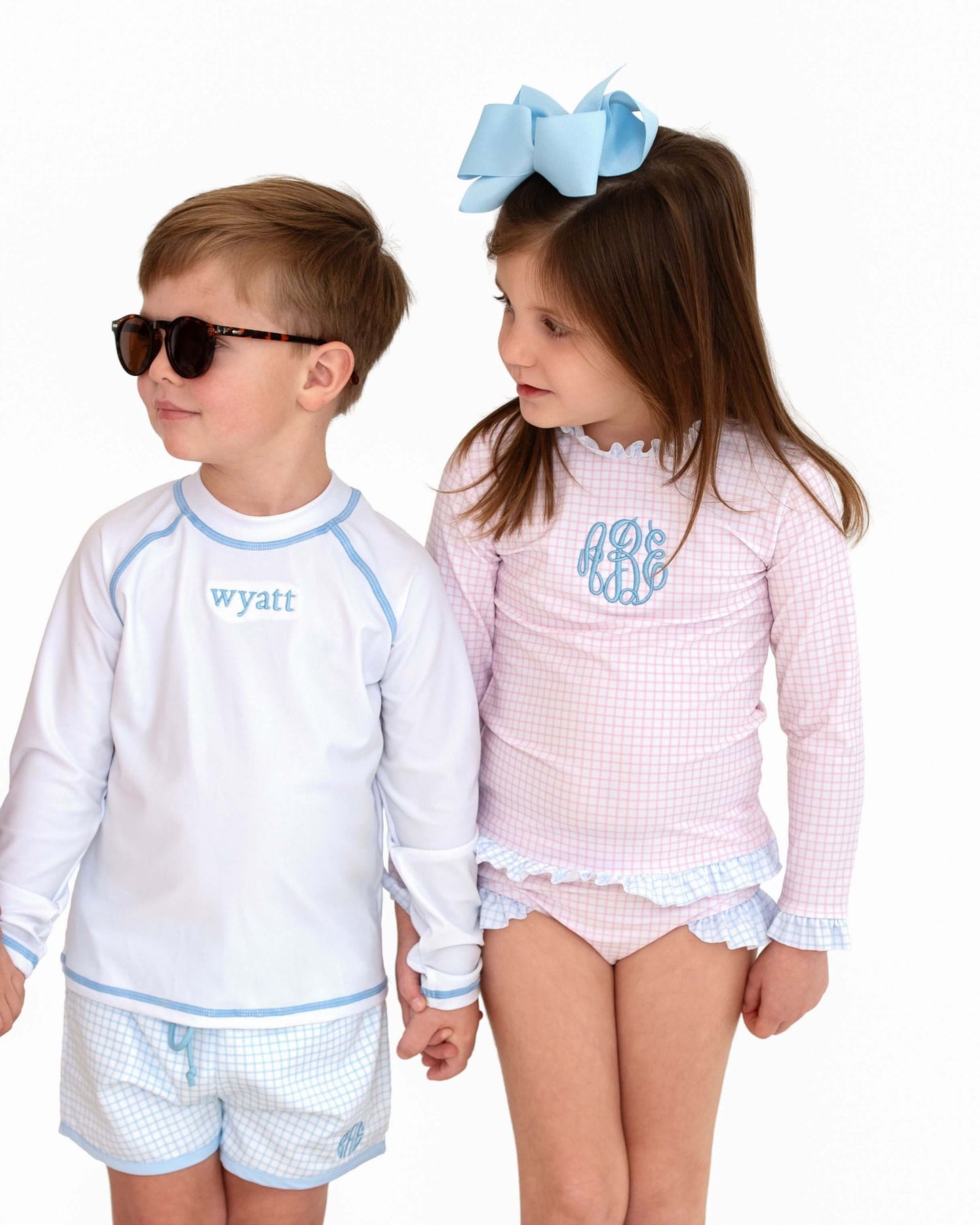 Two children wearing matching outfits with 'wyatt' and 'mona' text on a white background