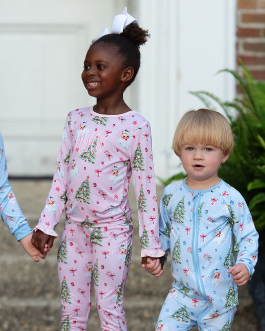 Two children wearing matching pajama sets with a floral pattern outdoors.