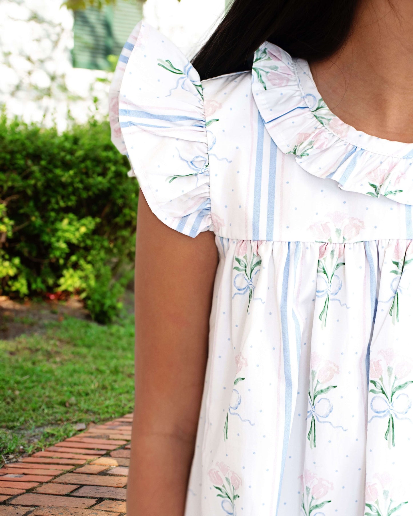 Woman wearing a floral dress with a blurred outdoor background
