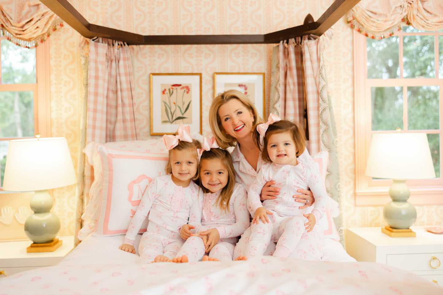 Woman with three children in a bedroom with pink accents