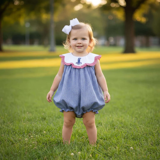Young girl in a blue checkered dress with a white bow standing on grass