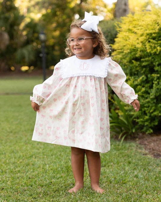 Young girl in a floral dress standing outdoors on grass