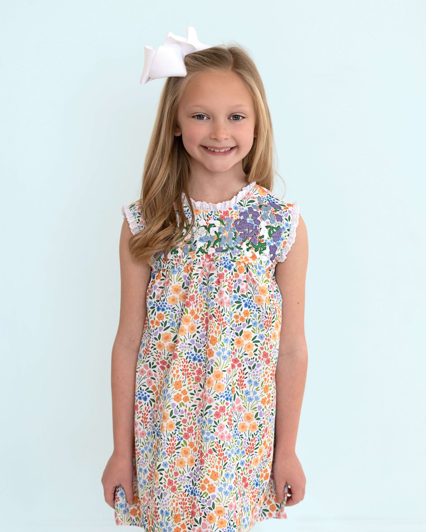 Young girl wearing a floral dress with a blue background