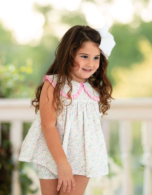 Young girl wearing a floral dress with pink trim outdoors