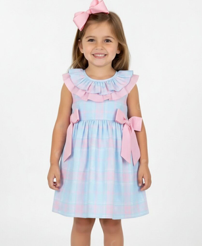 Young girl wearing a light blue dress with pink ruffles and bows on a white background