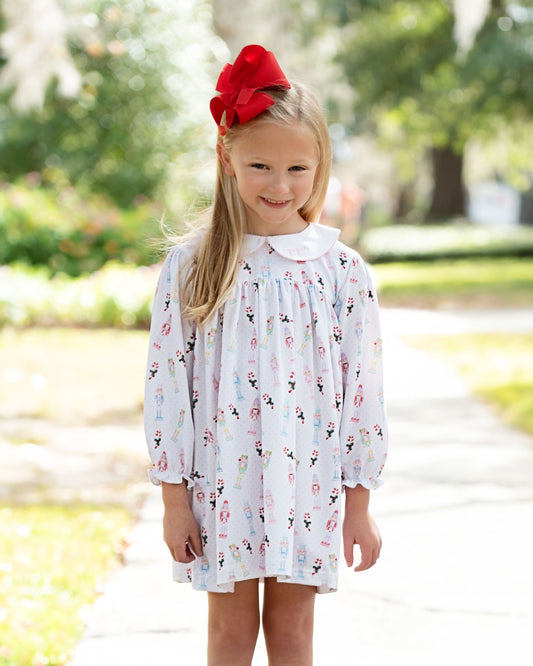 Young girl wearing a white dress with a floral pattern outdoors