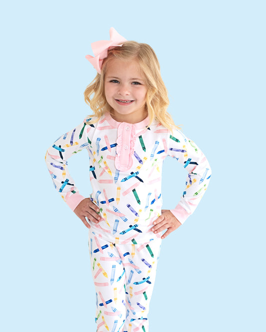 Young girl wearing crayon print pajamas.